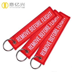 Free sample top quality customized woven remove before flight tag keychain 